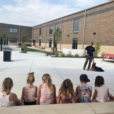 Children at Safety Town watching a police officer and a K9 officer.